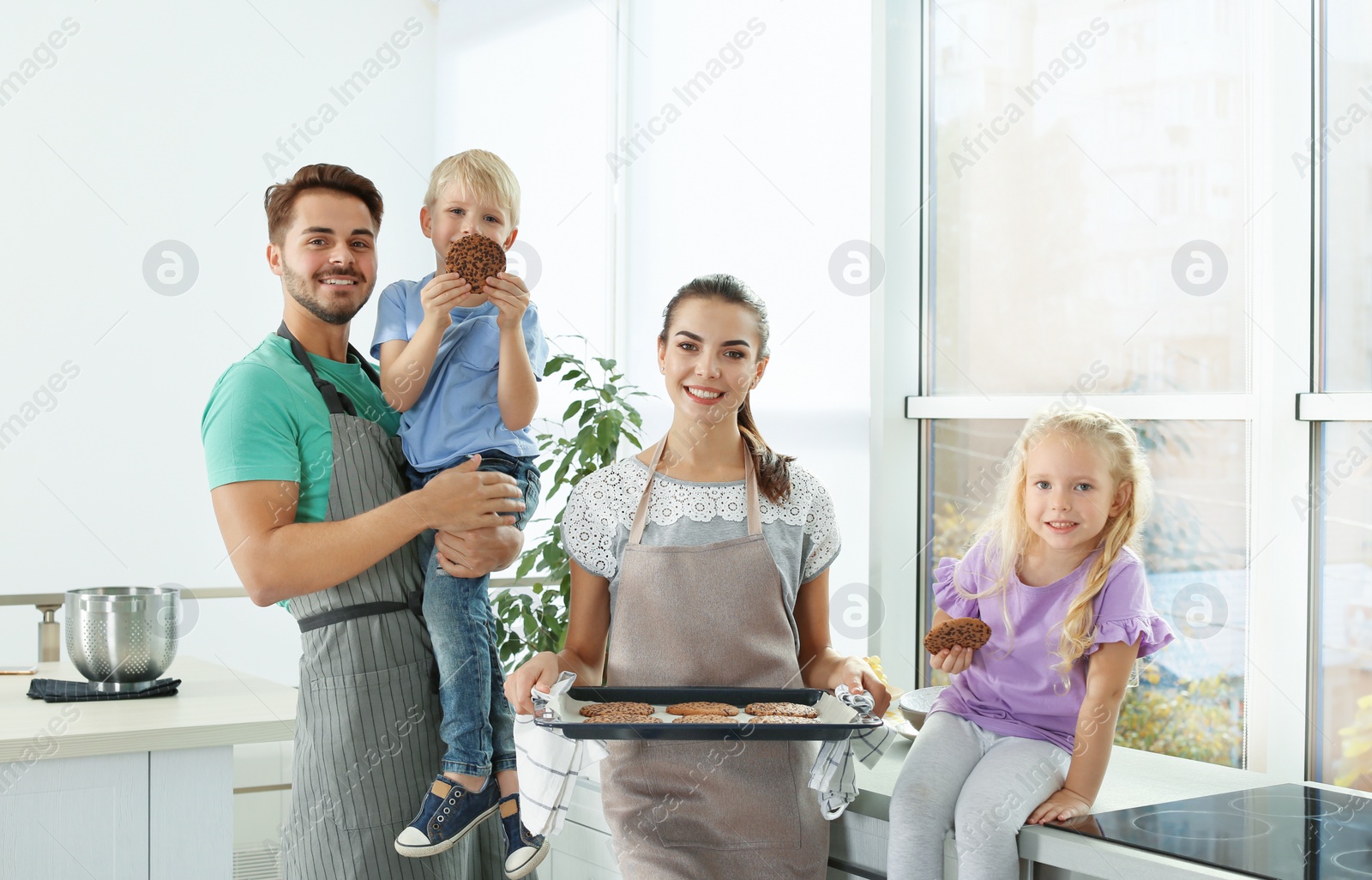 Photo of Happy family with homemade oven baked cookies in kitchen