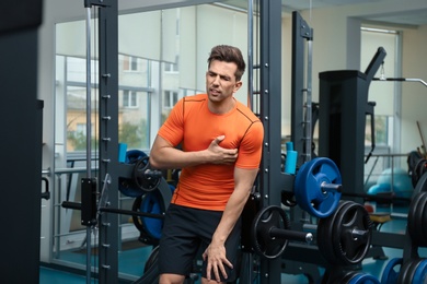 Young man having heart attack in gym