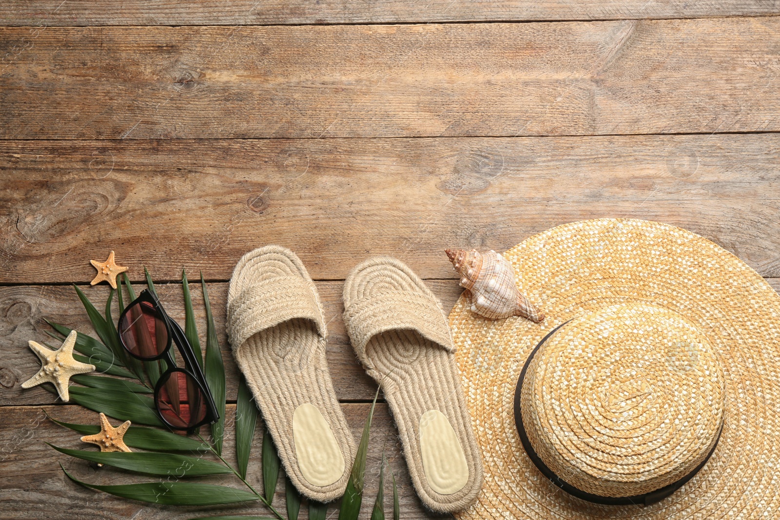 Photo of Beach accessories on wooden table, flat lay. Space for text