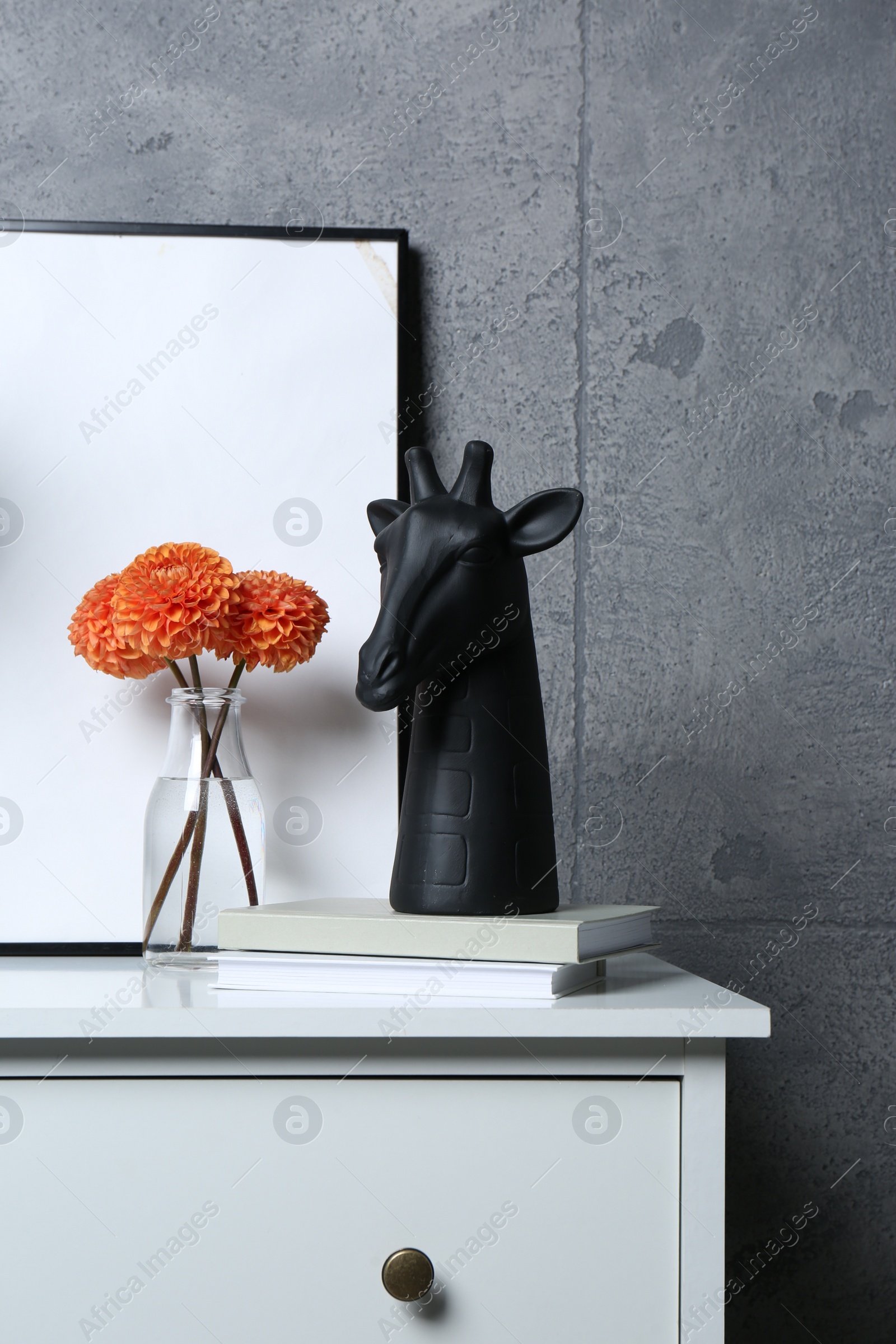 Photo of Stylish decor, vase with flowers and picture on chest of drawers near grey wall indoors, space for text. Interior design