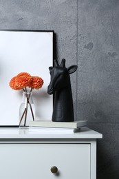 Photo of Stylish decor, vase with flowers and picture on chest of drawers near grey wall indoors, space for text. Interior design