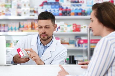 Photo of Professional pharmacist giving medicine to customer in drugstore