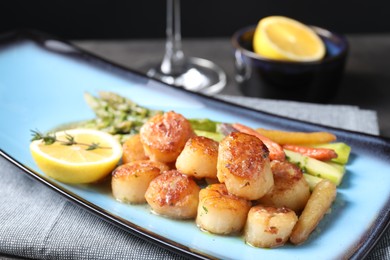 Delicious fried scallops with asparagus served on grey table, closeup