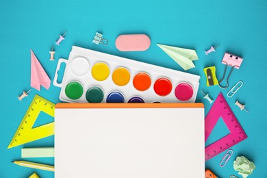 Photo of Different school stationery items and notebook on light blue background, flat lay with space for text. Back to school