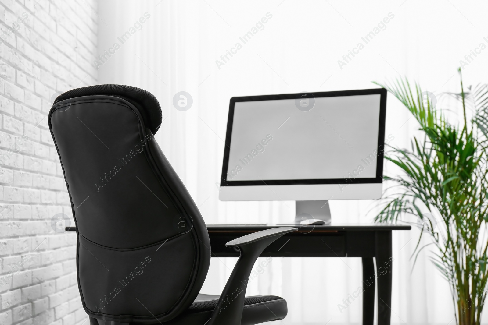 Photo of Stylish workplace interior with modern office chair