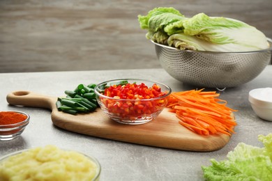 Photo of Fresh Chinese cabbages and other ingredients for kimchi on light grey table