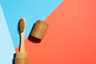 Photo of Bamboo toothbrush in case on color background, top view. Space for text