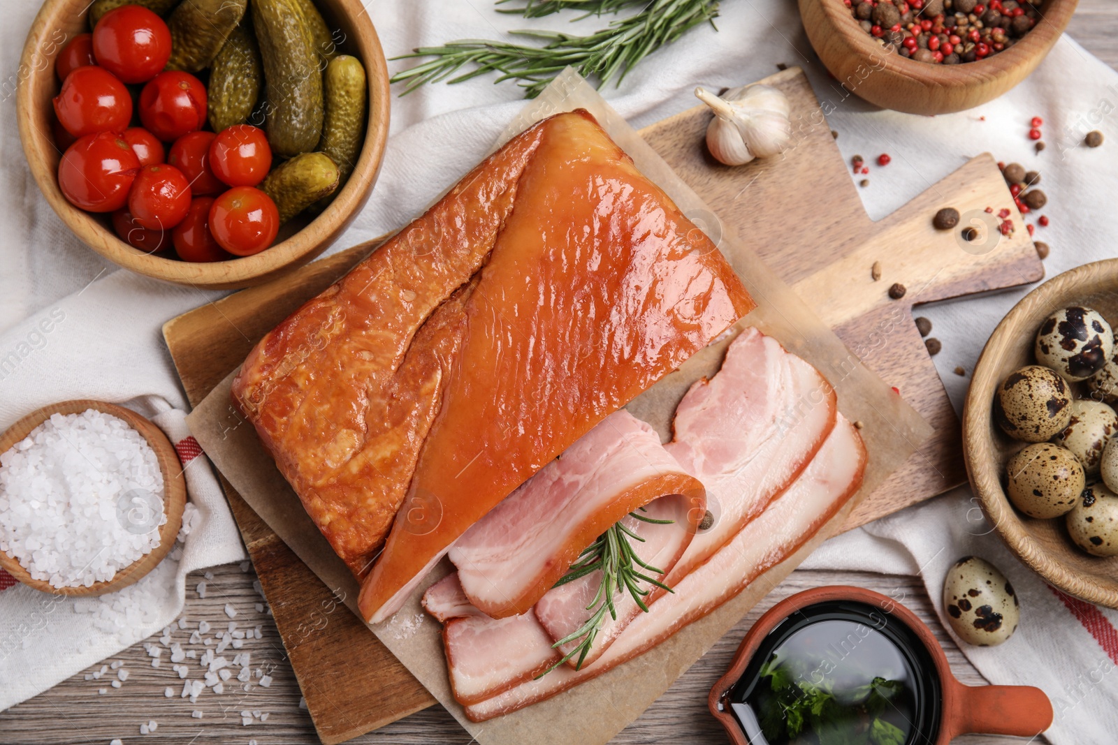 Photo of Flat lay composition with delicious smoked bacon on wooden table