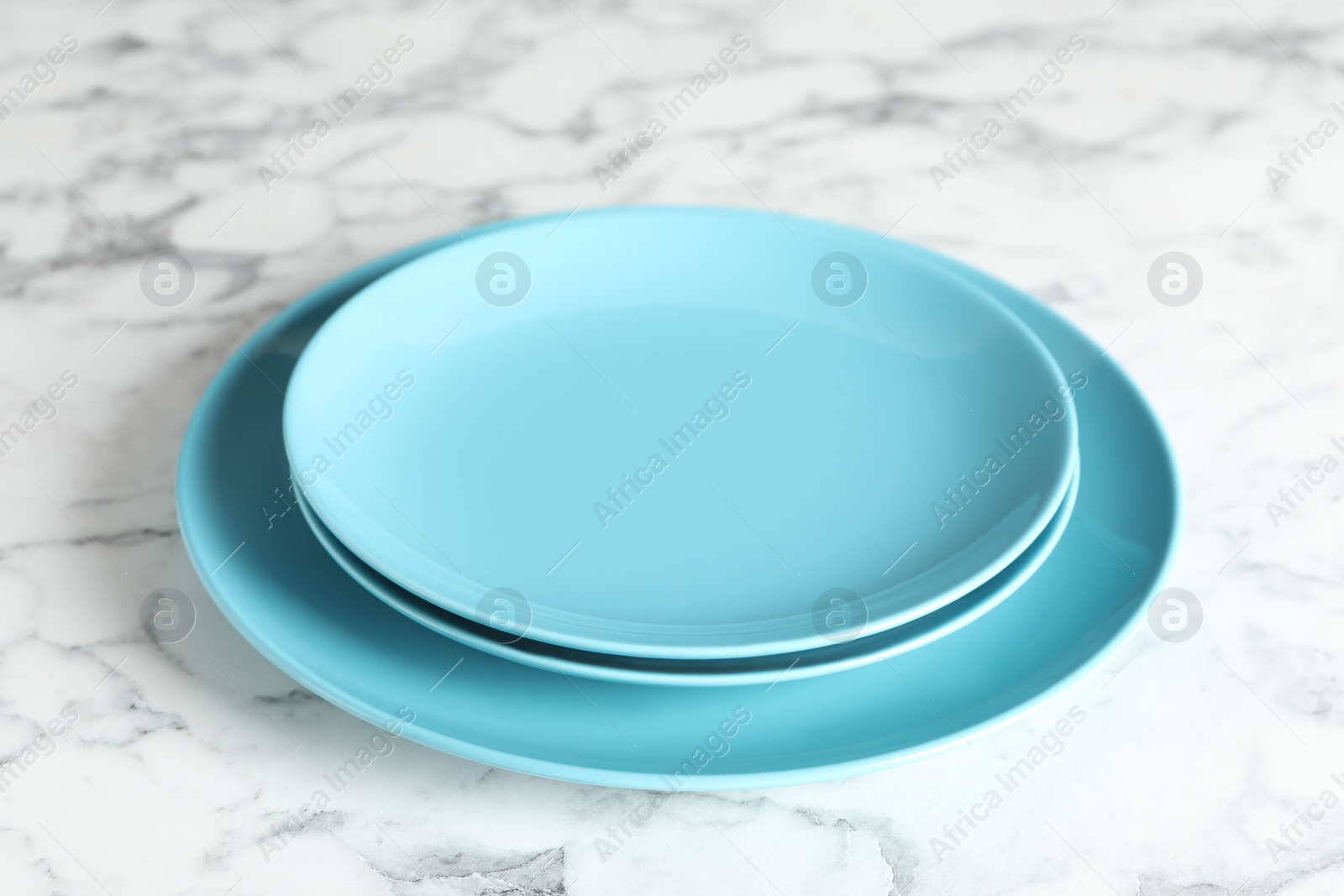 Photo of Elegant new empty plates on white marble table