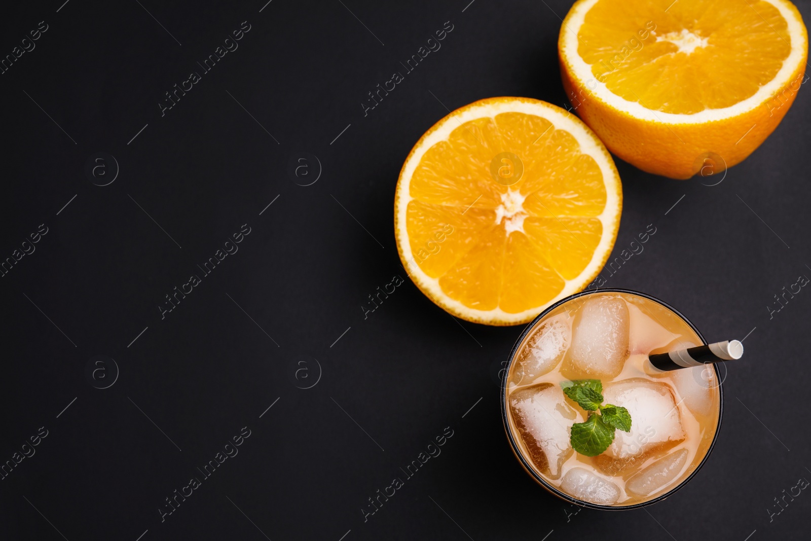 Photo of Fresh alcoholic Tequila Sunrise cocktail on black table, flat lay. Space for text