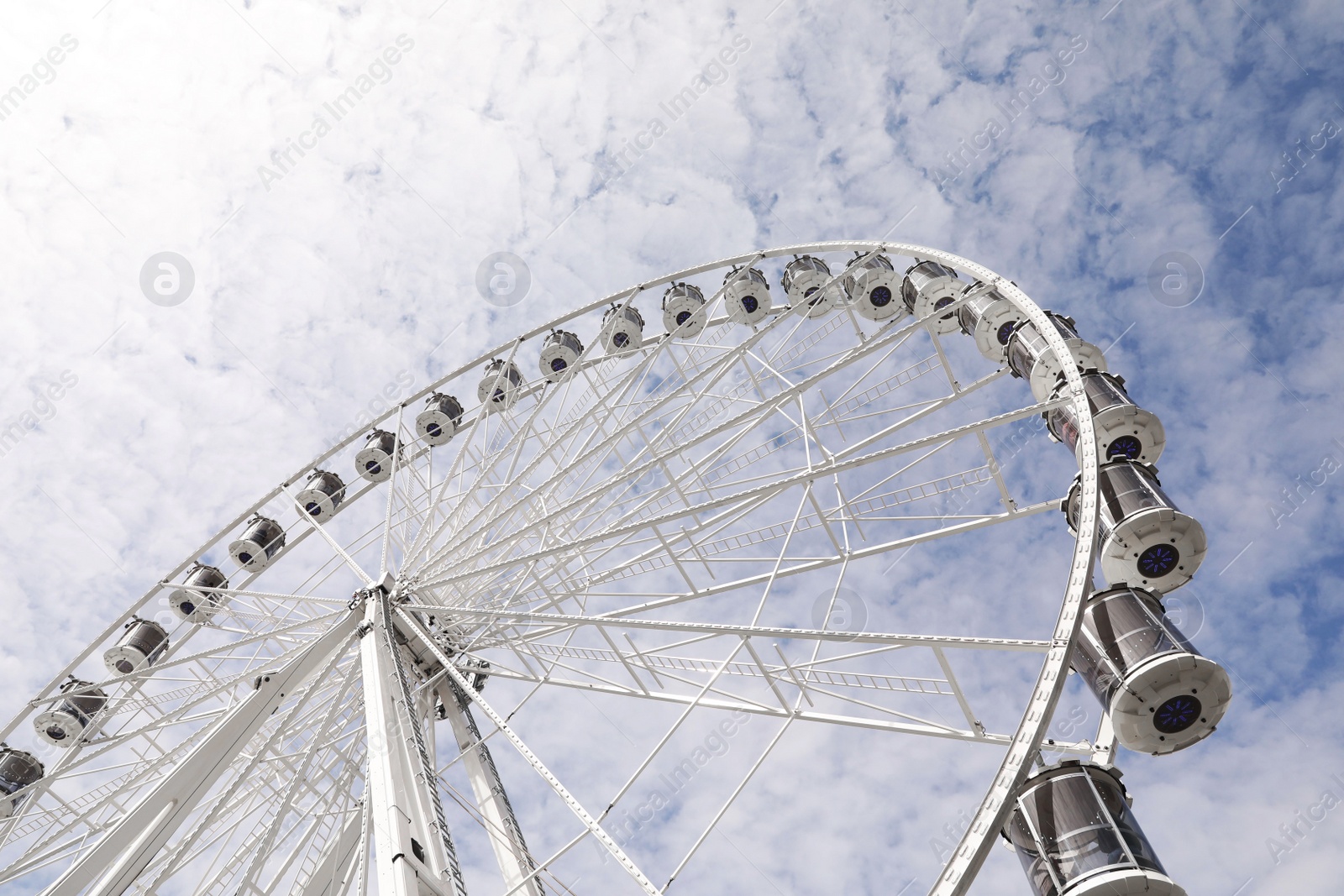 Photo of Beautiful Ferris wheel against cloudy sky, low angle view