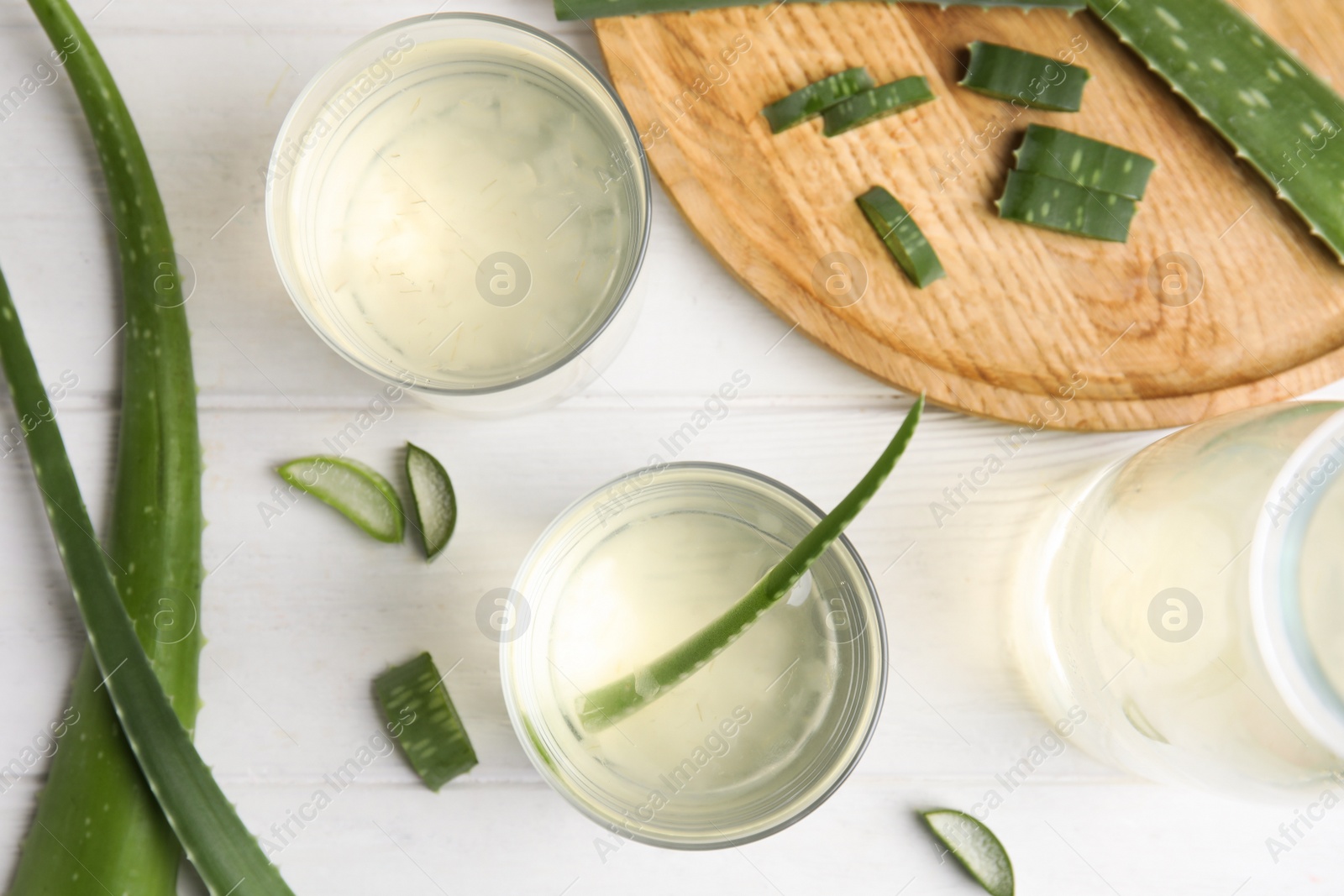 Photo of Flat lay composition with fresh aloe drink and leaves on white wooden table