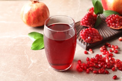 Photo of Composition with glass of fresh pomegranate juice on table