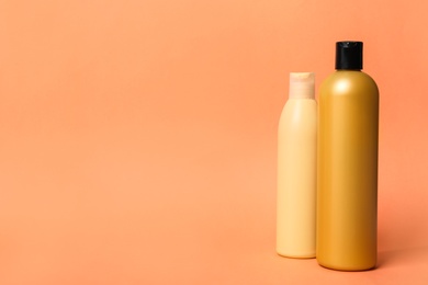 Photo of Bottles with cosmetic products on orange background. Mockup for design