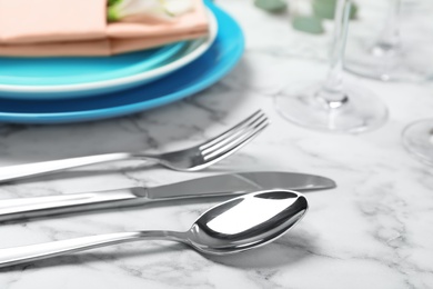 Cutlery and blurred plates with napkin on background
