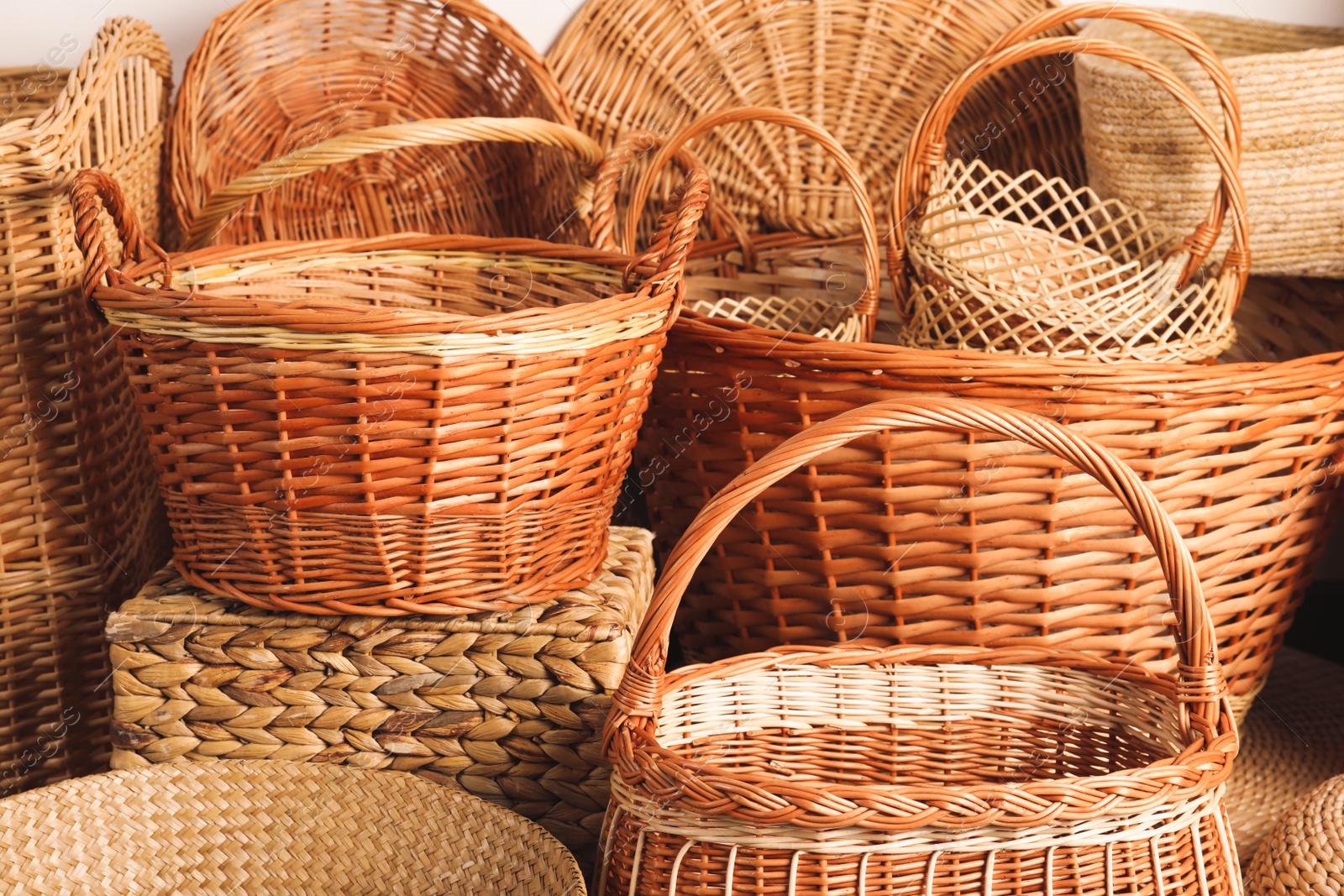 Photo of Many different wicker baskets made of natural material as background, closeup