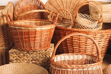 Many different wicker baskets made of natural material as background, closeup