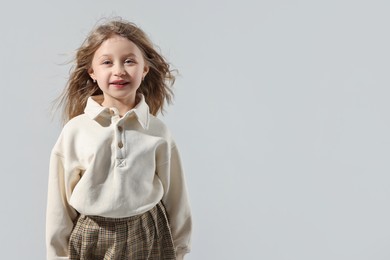 Fashion concept. Stylish girl posing on light grey background. Space for text