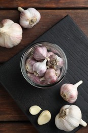 Many fresh garlic bulbs on wooden table, flat lay