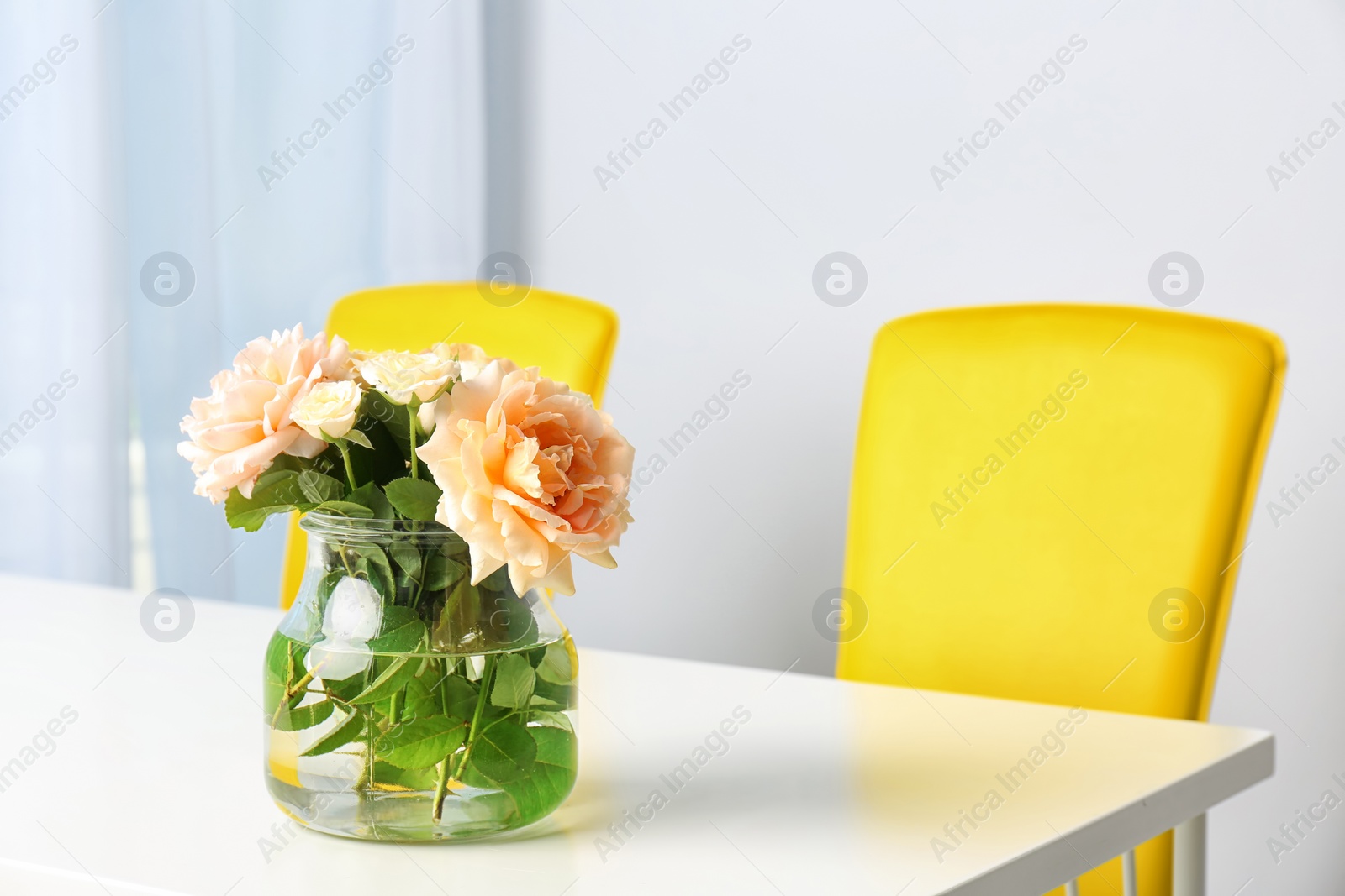 Photo of Vase with blooming flowers on table indoors