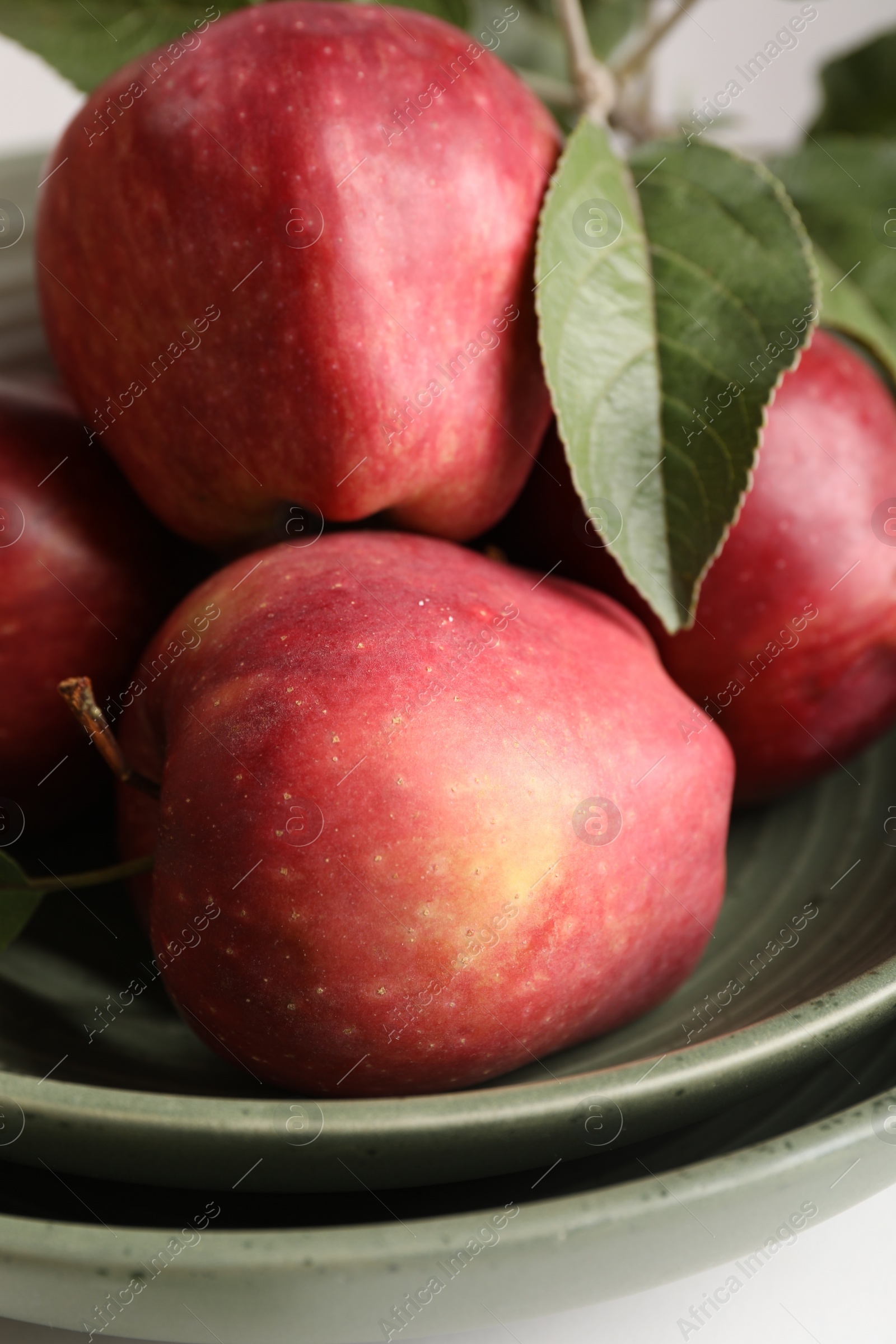 Photo of Fresh red apples and leaves on table, closeup