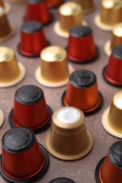 Many coffee capsules on brown table, closeup