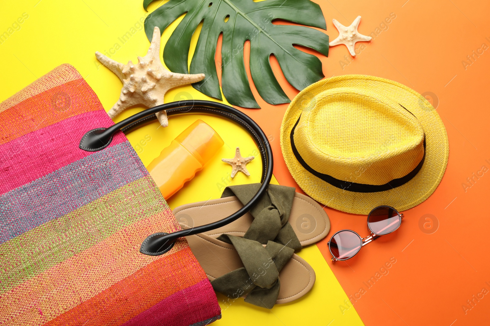 Photo of Stylish bag and beach accessories on color background, flat lay