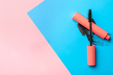 Mascara and smear on color background, flat lay with space for text. Makeup product