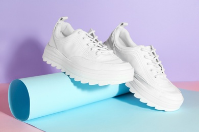 Photo of Pair of stylish sneakers on color background