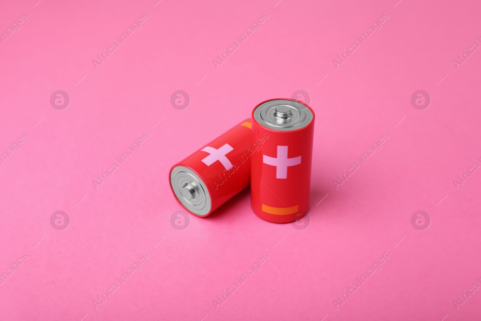 Photo of New C size batteries on pink background