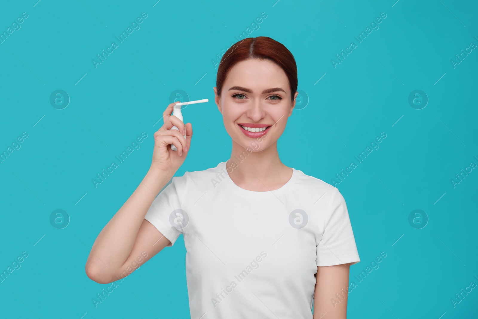 Photo of Woman using ear spray on light blue background