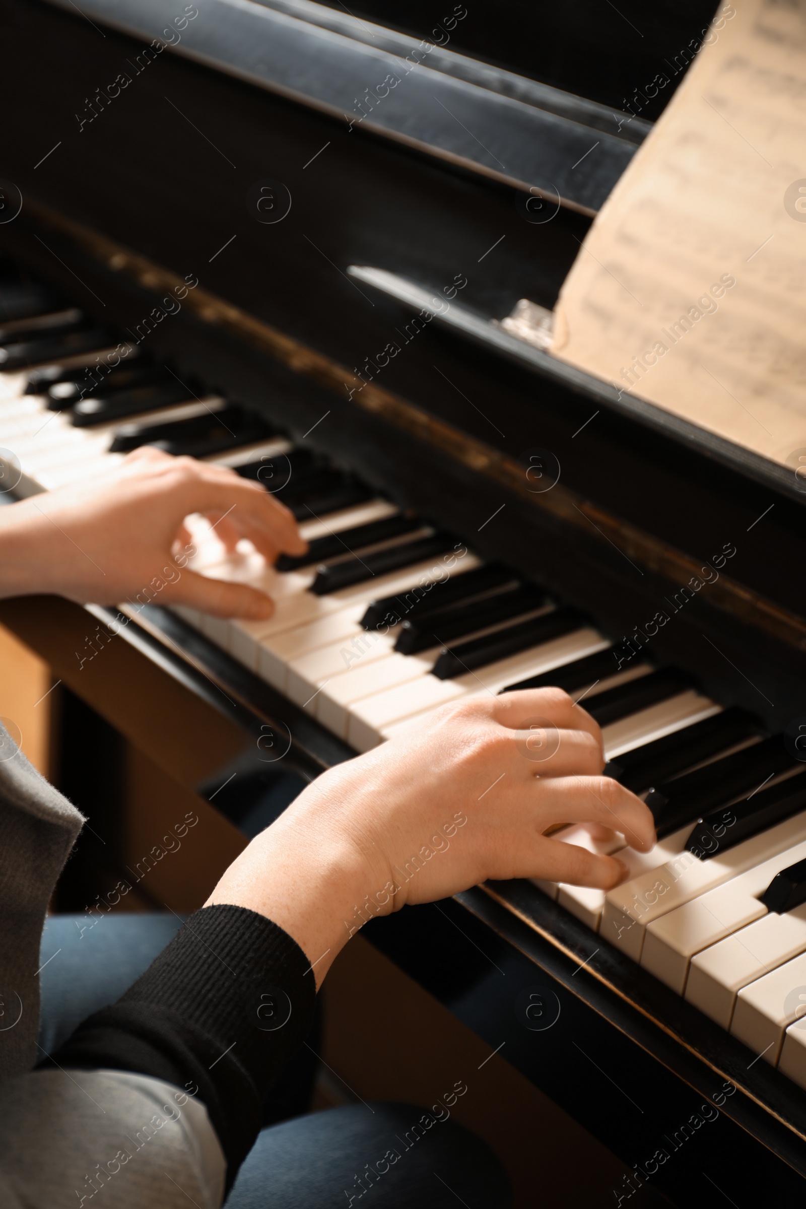 Photo of Young woman playing piano, closeup. Music lesson