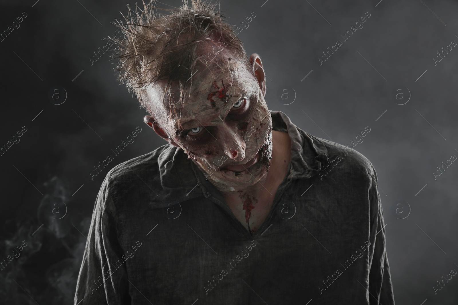 Photo of Scary zombie on dark background. Halloween monster