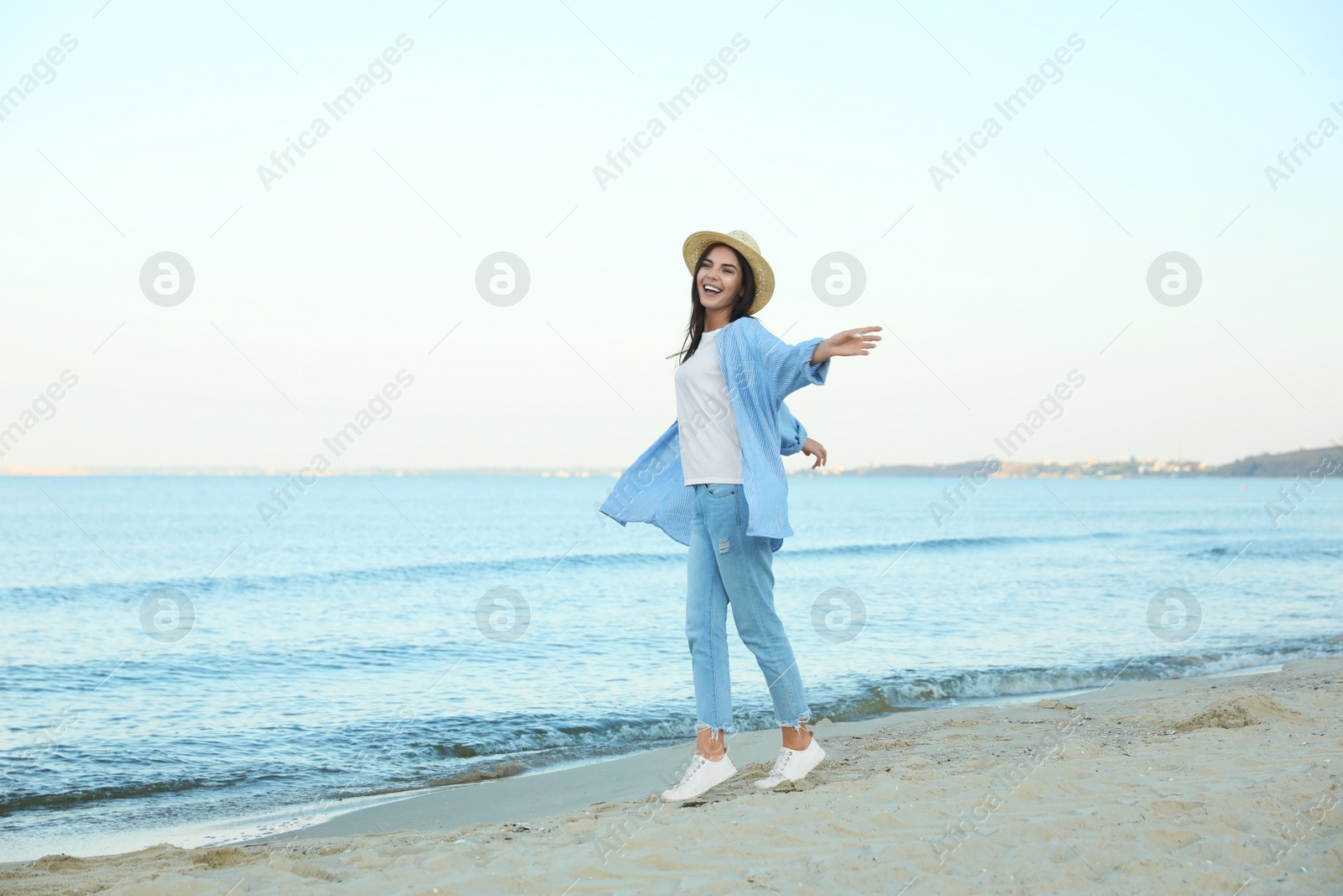 Photo of Beautiful young woman in casual outfit on beach