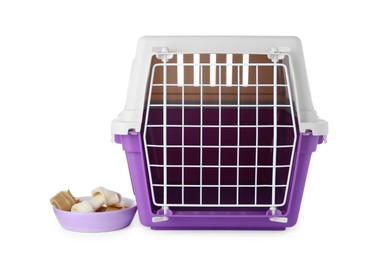 Photo of Violet pet carrier and bowl with chewing bones isolated on white