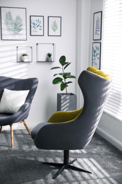 Photo of Comfortable armchairs near window in light room