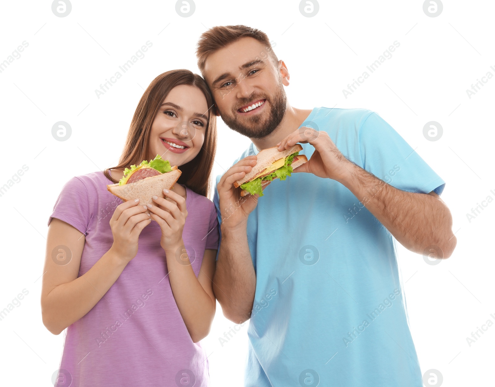 Photo of Young couple with tasty sandwiches on white background