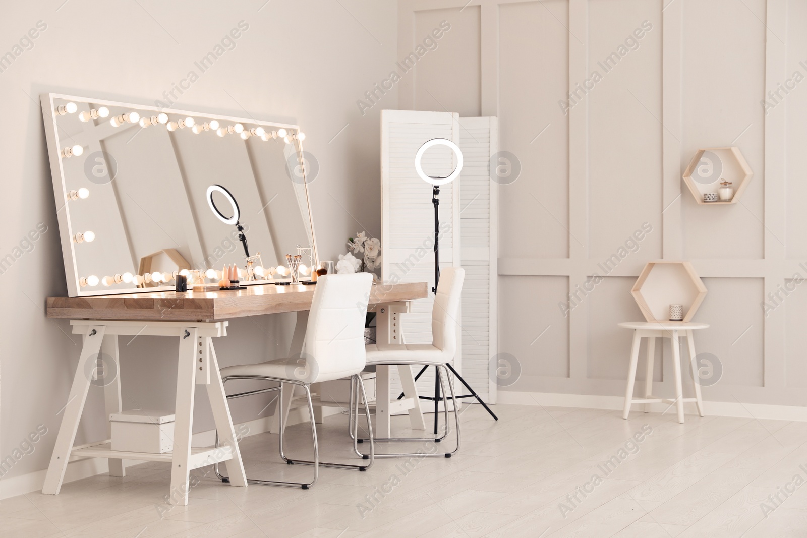 Photo of Modern mirror with light bulbs on dressing table in makeup room