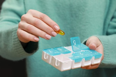 Photo of Woman taking pill from plastic box , closeup