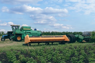 Photo of Modern combine harvester, tractor and plough in agricultural field