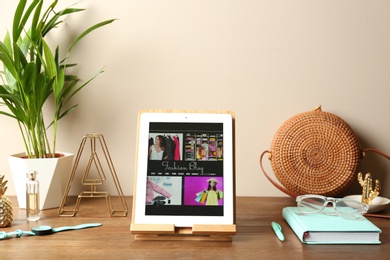 Stylish workplace with modern tablet on table near color wall. Fashion blogger
