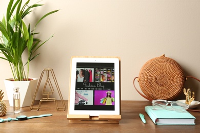 Photo of Stylish workplace with modern tablet on table near color wall. Fashion blogger