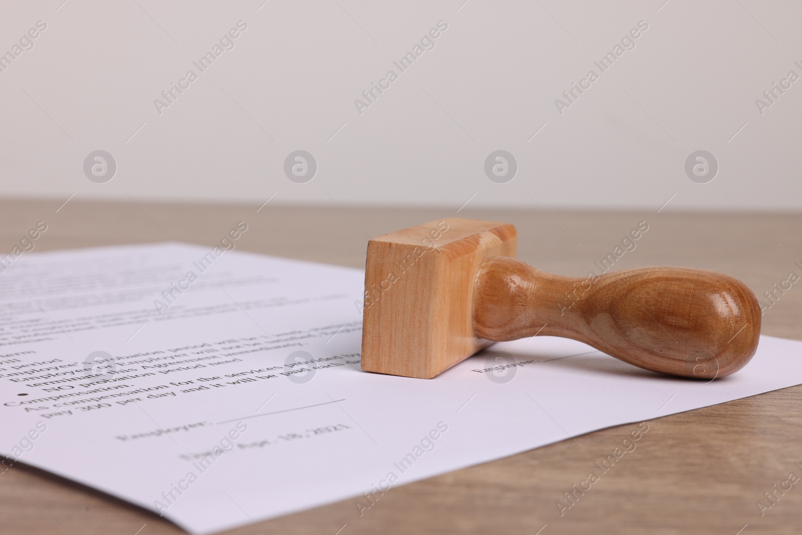 Photo of One stamp tool and document on wooden table, closeup