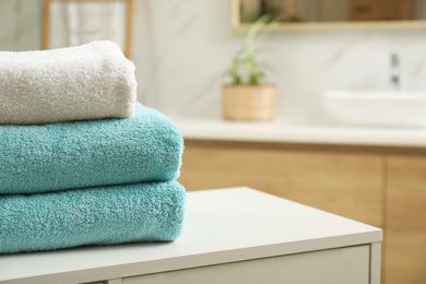 Stack of clean towels on table indoors. Space for text