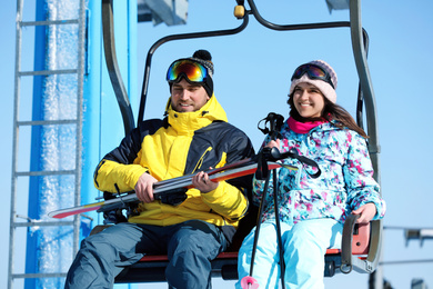 People using chairlift at mountain ski resort. Winter vacation