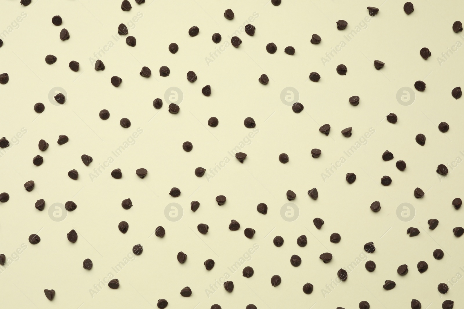 Photo of Delicious chocolate chips on beige background, top view