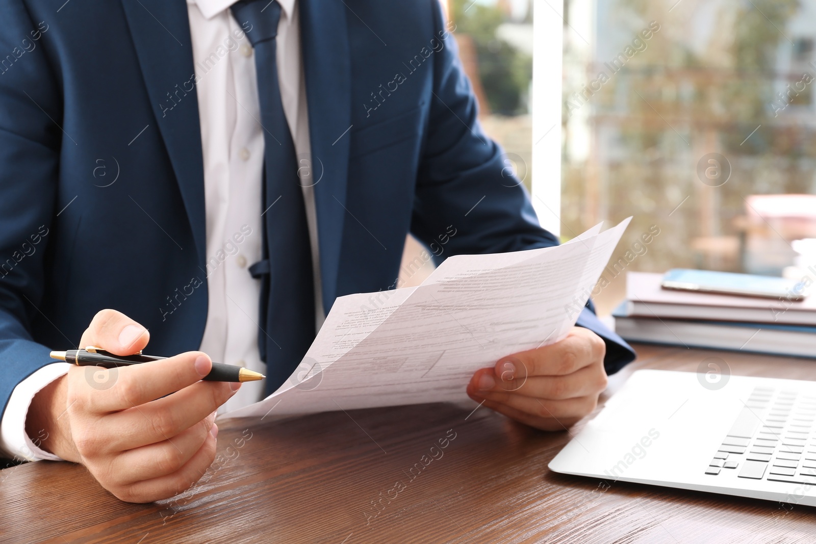 Photo of Lawyer working with documents at table, focus on hands