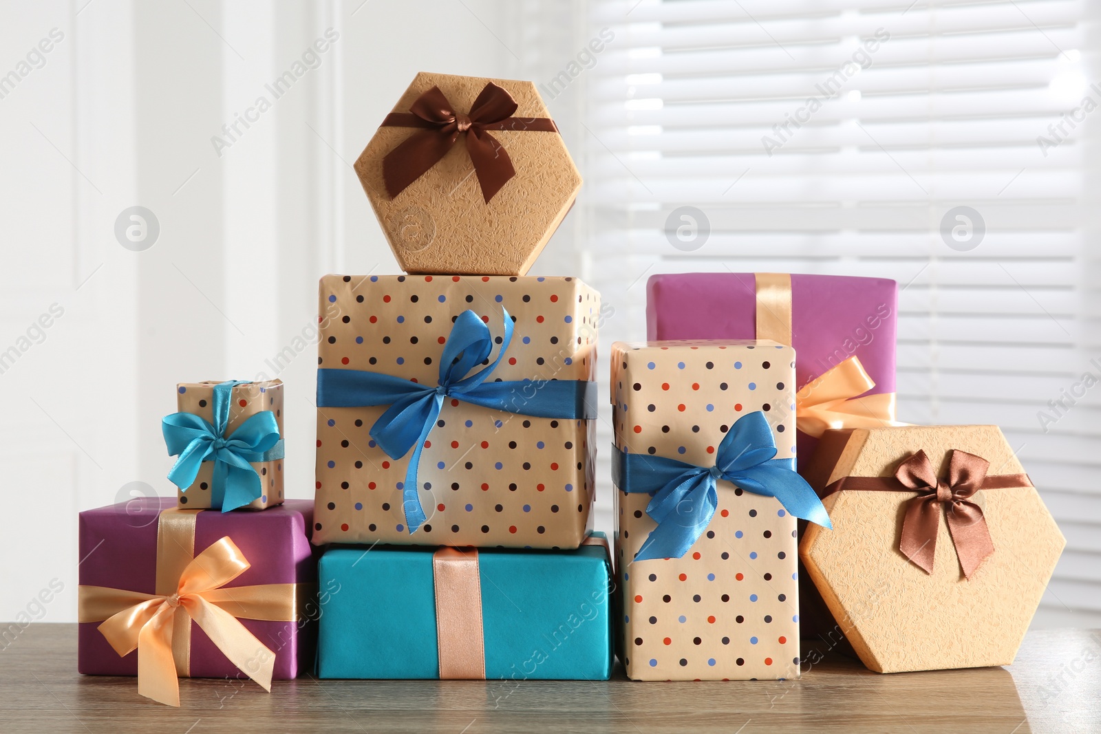 Photo of Heap of wrapped gift boxes on wooden table. Happy holiday