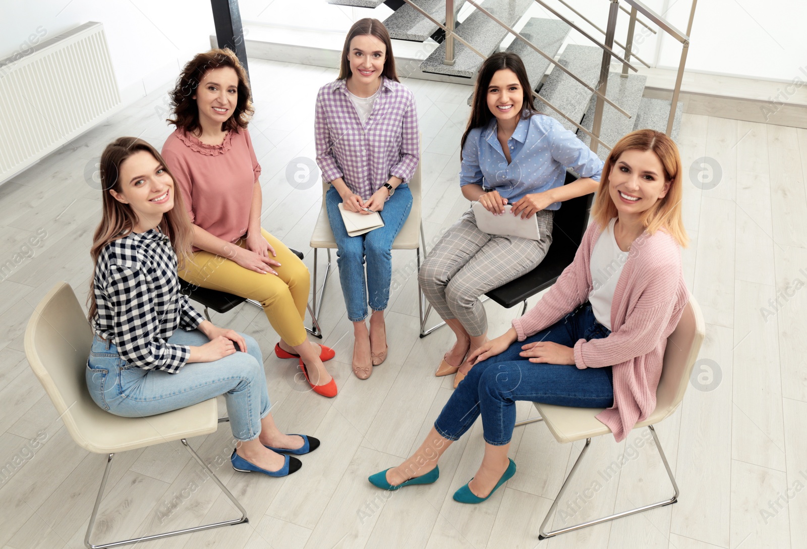 Photo of Cheerful ladies at meeting indoors, view from above. Women power concept