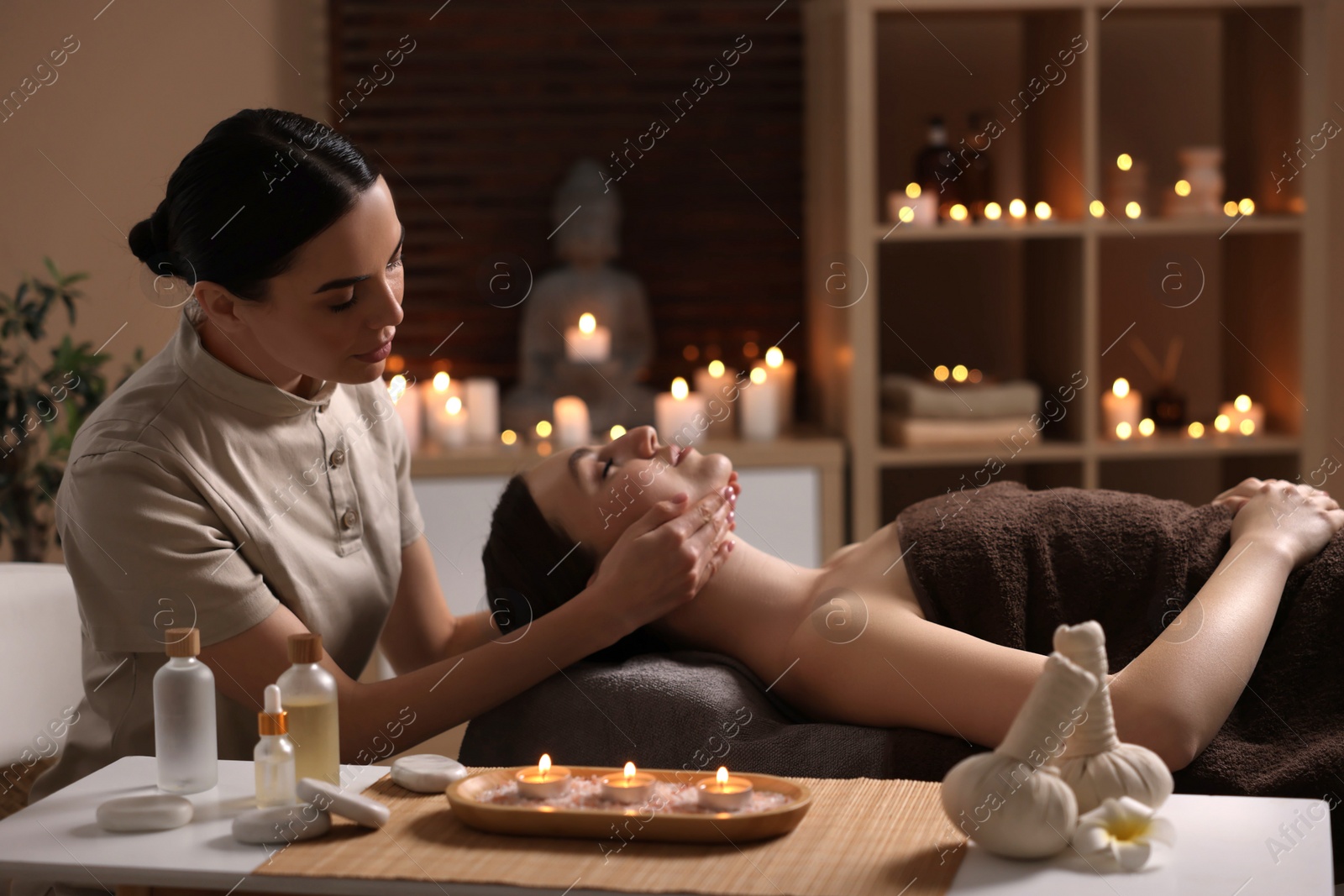 Photo of Spa therapy. Beautiful young woman lying on table during massage in salon